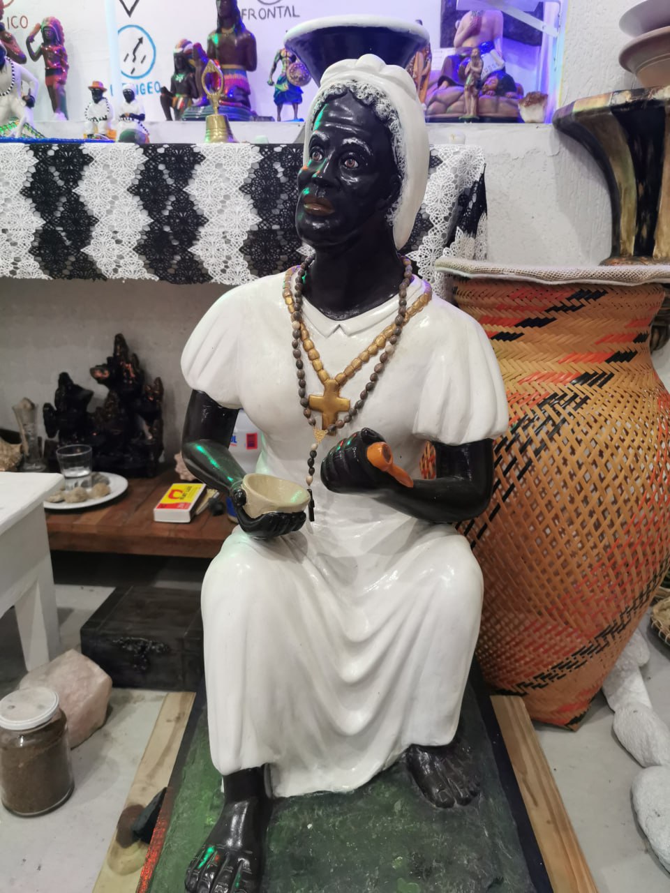 Imagem de uma Preta Velha sentada em frente ao Altar